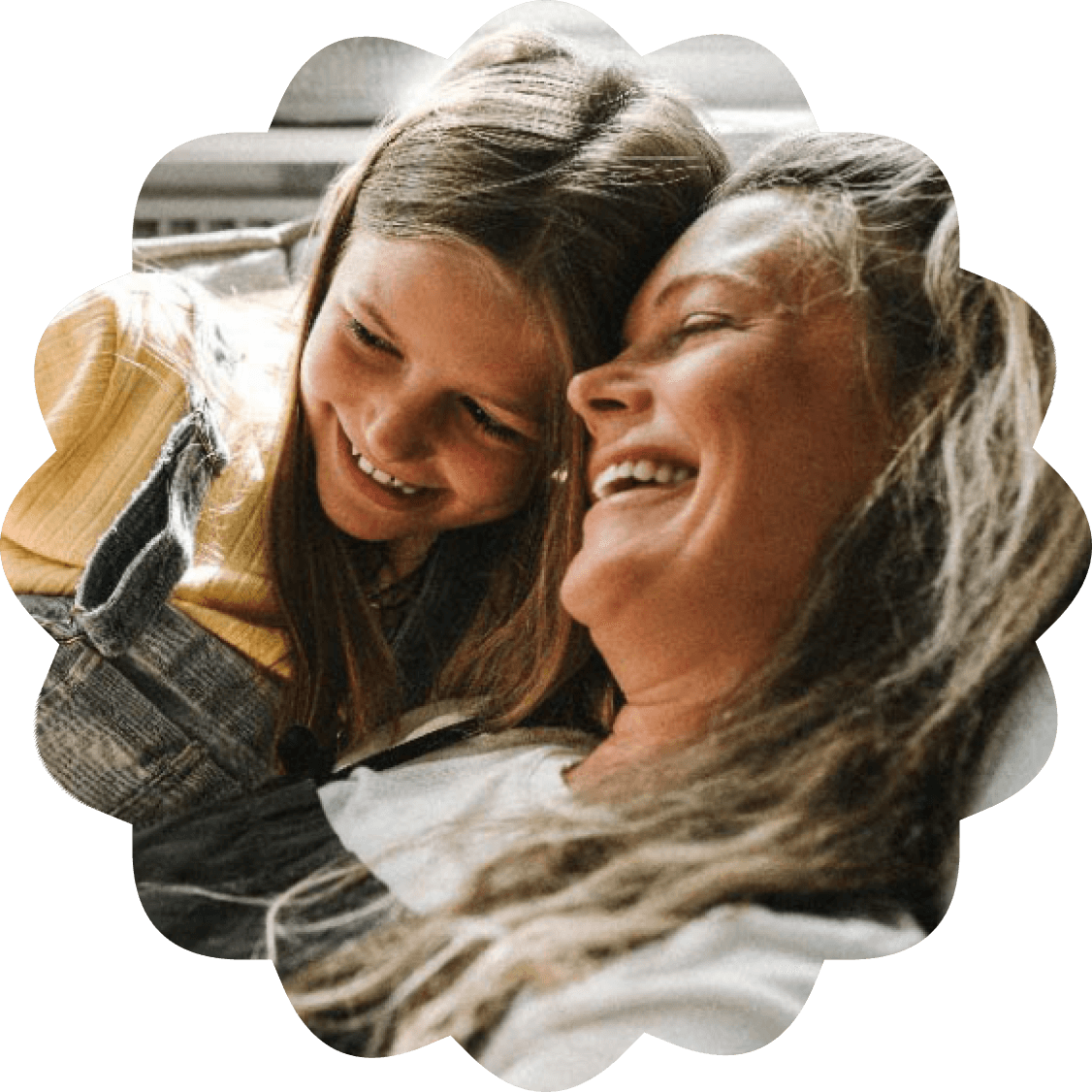A person and their child laugh happily together while they embrace.